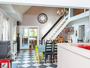 A dining area with a checkered floor, a staircase, and a clock on the wall. - 19 Person Holiday Home in Logstor-by Traum (Logstor)