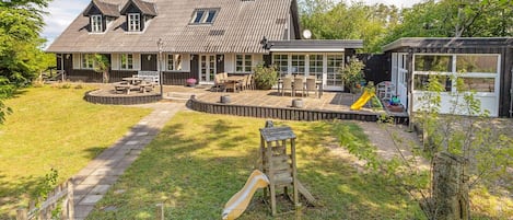 A house with a patio, a play area, and a fenced yard.