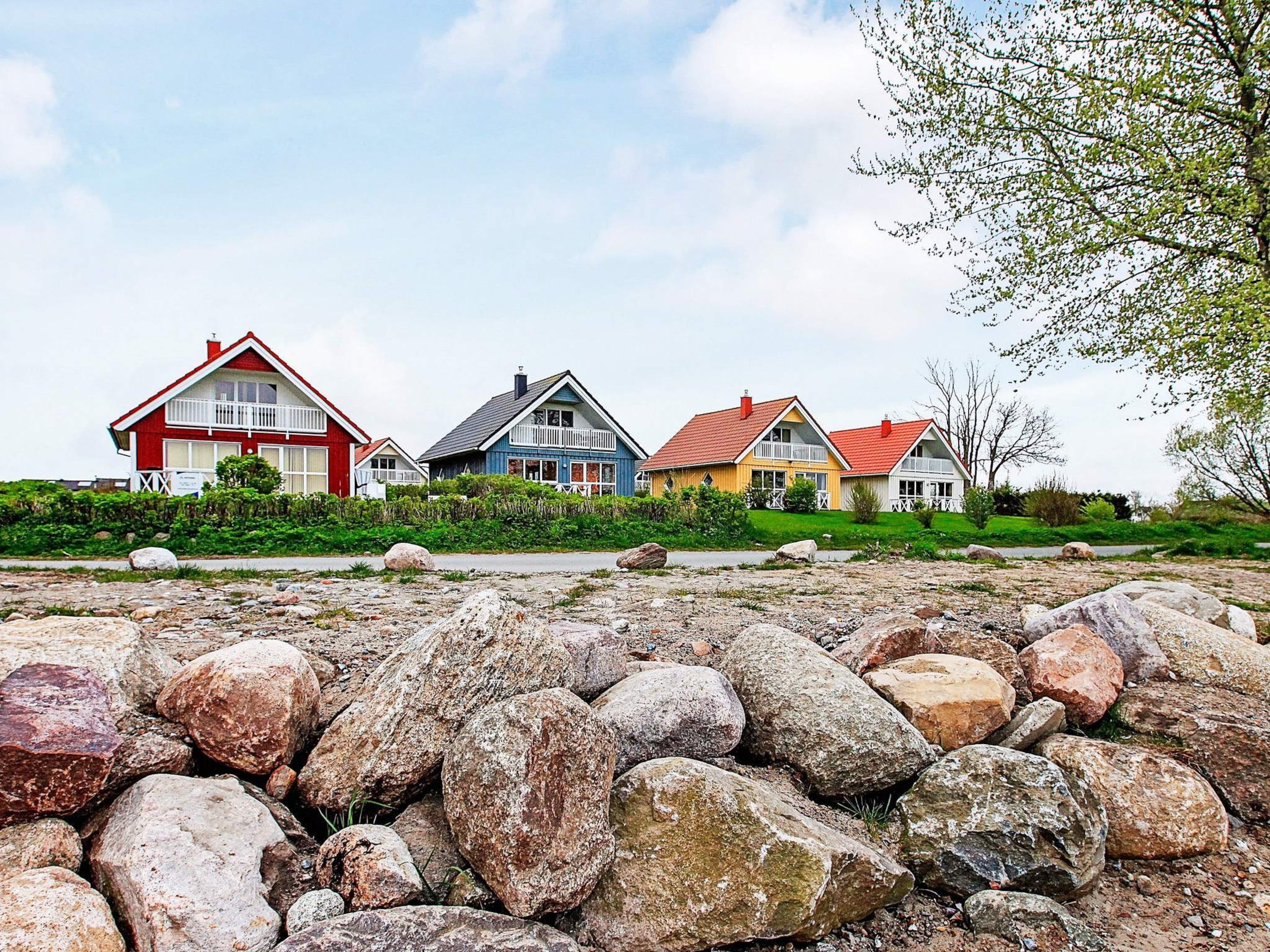 A row of colorful houses with a rocky foreground.