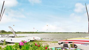 Une vue sur le lac, avec des bateaux et du matériel de kitesurf.