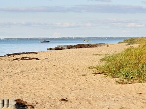 A sandy beach with a wooden jetty extending into the water. - Holiday Home in Gelting (Gelting)