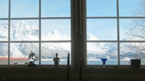 A room with large windows offering a view of snow-covered mountains. - 6 Person Holiday Home in Hamnvik (Ibestad)