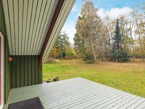 A wooden deck with a view of a grassy area and trees. - 5 Person Holiday Home in Martofte (Martofte)