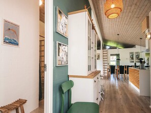 A modern interior with a wooden ceiling, a green chair, and a dining area with wooden furniture. - 5 Star Holiday Home in Ebeltoft (Ebeltoft)