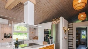 A modern kitchen with a central island, stainless steel appliances, and a wooden ceiling. - 14 Person Holiday Home in Ebeltoft-by Traum (Ebeltoft)
