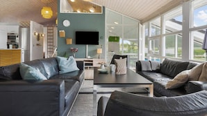 A modern living room with a sofa, coffee table, and a TV. - 14 Person Holiday Home in Ebeltoft-by Traum (Ebeltoft)