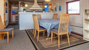 A cozy kitchen with wooden cabinets, a central island, and hanging pendant lights. - 8 Person Holiday Home in Harboore (Harboore)