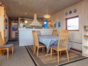 A cozy kitchen with wooden cabinets, a central island, and hanging pendant lights. - 8 Person Holiday Home in Harboore (Harboore)
