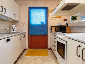 A compact kitchen with white cabinets, a Siemens dishwasher, a stove, and a microwave. - 8 Person Holiday Home in Harboore (Harboore)