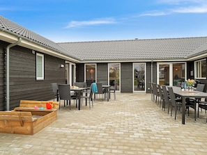 A patio area with outdoor furniture and a wooden play structure. - Spacious Holiday Home in Grenå near Sea (Grenaa)