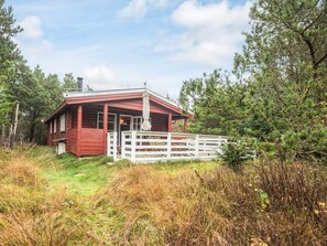 A cabin with a porch and a white fence. - 6 Person Holiday Home in Oksbol (Oksbol)