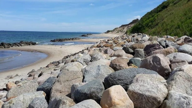 Ein felsiger Strand mit blauem Himmel.