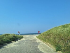 A gravel road leading to a beach with speed limit signs and a no parking sign. - 4 Star Holiday Home in Pandrup (Pandrup)