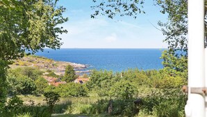 A coastal landscape with a view of the sea, a path leading to a building, and surrounding greenery. - 4 Person Holiday Home in Allinge (Allinge)