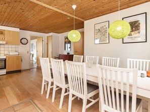A dining area with a white table and chairs, wooden ceiling, and two green spherical light fixtures. - 8 Person Holiday Home in Frostrup (Frøstrup)