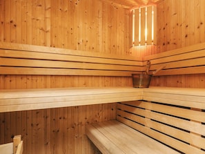 A sauna with wooden benches and a metal bucket. - 5 Star Holiday Home in Hals (Hals)