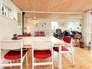 A spacious living area with a wooden ceiling, a dining table with chairs, a sofa, and a chair. - 6 Person Holiday Home in Store Fuglede (Store Fuglede)