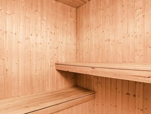 A wooden sauna with a bench and a shelf.
