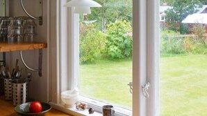A kitchen with a window, a bowl with a tomato, and utensils on the counter. - 4 Person Holiday Home in Boras (Borås)