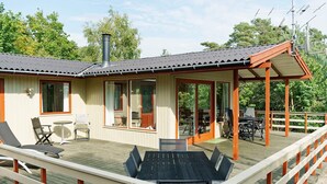Ett trädäck med utemöbler, en täckt uteplats och en skorsten.
