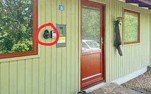 A building with a green exterior, a red door, and a mailbox mounted on the wall. - 6 Person Holiday Home in Aakirkeby (Akirkeby)