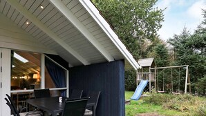 A covered patio with a table and chairs, a slide, and a play structure. - 4 Star Holiday Home in Hals (Hals)