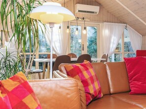 Una habitación acogedora con sofás de cuero, una mesa de comedor y bombillas colgantes.