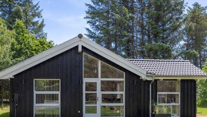 Un edificio moderno de madera con ventanas grandes y techo inclinado.