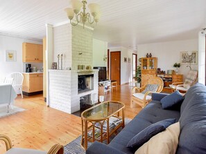 Un salon avec une cheminée, un canapé, une table basse et un coin repas doté de meubles en bois.