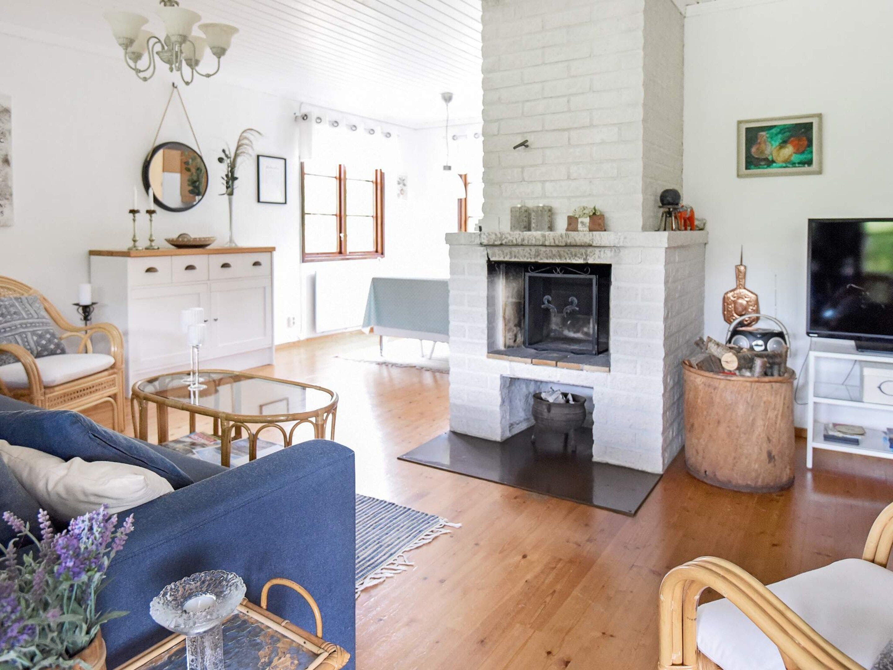 Una sala de estar con chimenea, televisor y comedor con mesa y sillas.