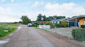 A rural road with houses on one side and a body of water on the other. - Seaside Charm at Binderup - By Traum Ferienwohnungen (Bjert)