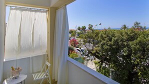 A balcony with a view of a beach, a table with a bottle and glasses, and a chair. - Beautiful apartment for 4 people with WIFI, TV and terrace (Pietrasanta)