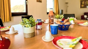 A dining table set with various food items, including bread, a bottle of juice, and condiments. - Cosy apartment in villa for 4 people with WIFI, A/C, TV, terrace and pets allowed (Bad Wildungen)