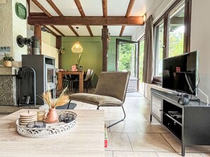 A modern kitchen with a dining area, a TV, and a fireplace.