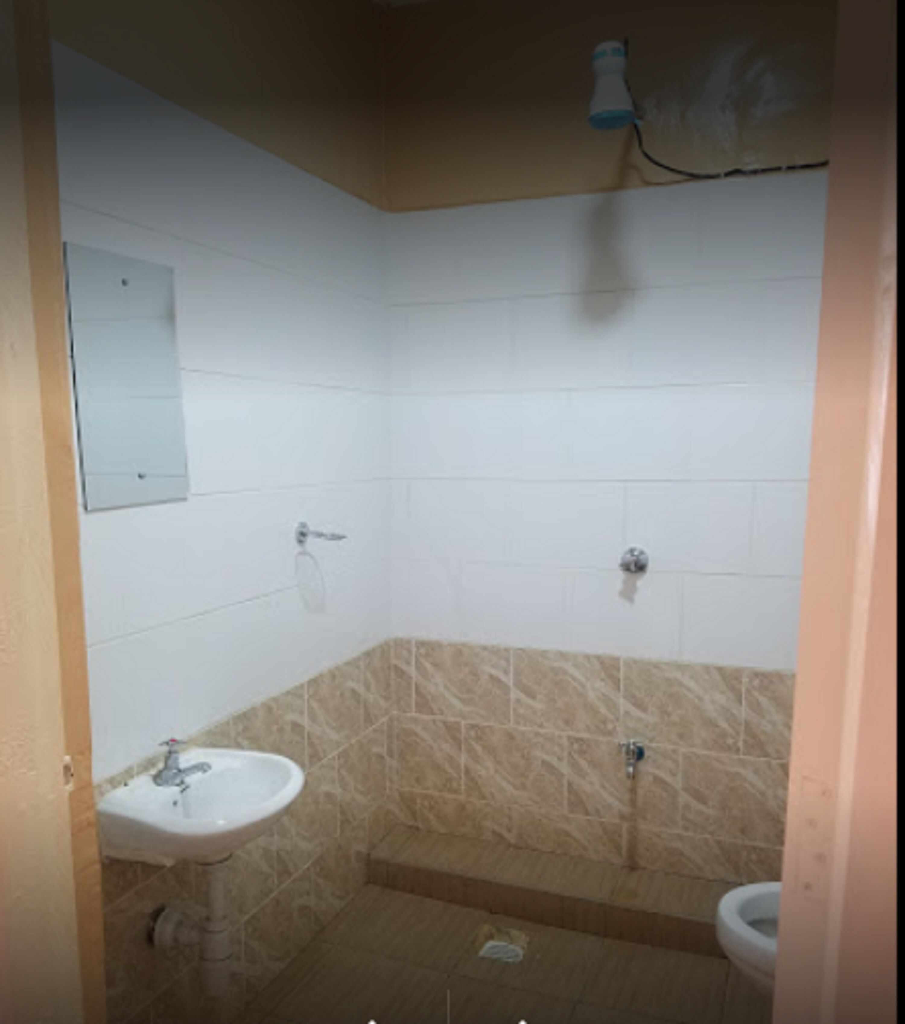 A small bathroom with a sink, toilet, and shower.
