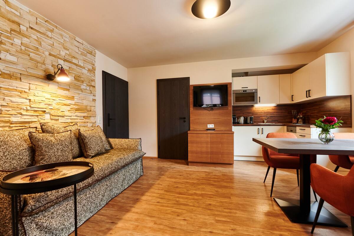 A modern living room with a stone wall, a sofa, and a coffee table.