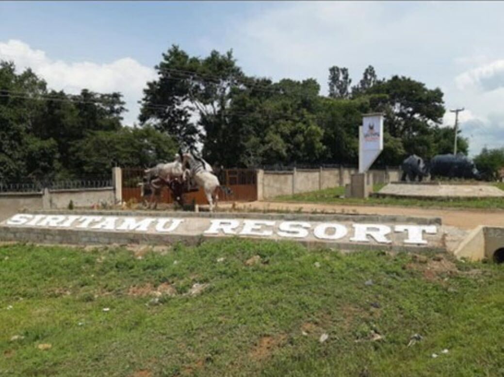 A sign for Siritamu Resort with a horse statue in the background.