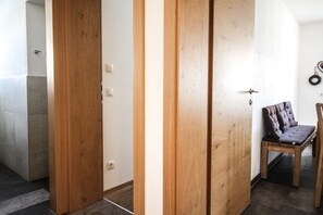 A hallway with wooden doors, a bench, and a wall-mounted ring light.