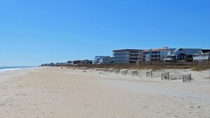 A beach with a row of houses along the shore. - A Place at the Beach II 2H - Ocean Front in Garden City Beach (Garden City)