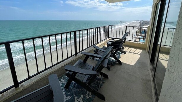 Ein Balkon mit Blick auf Strand und Meer.