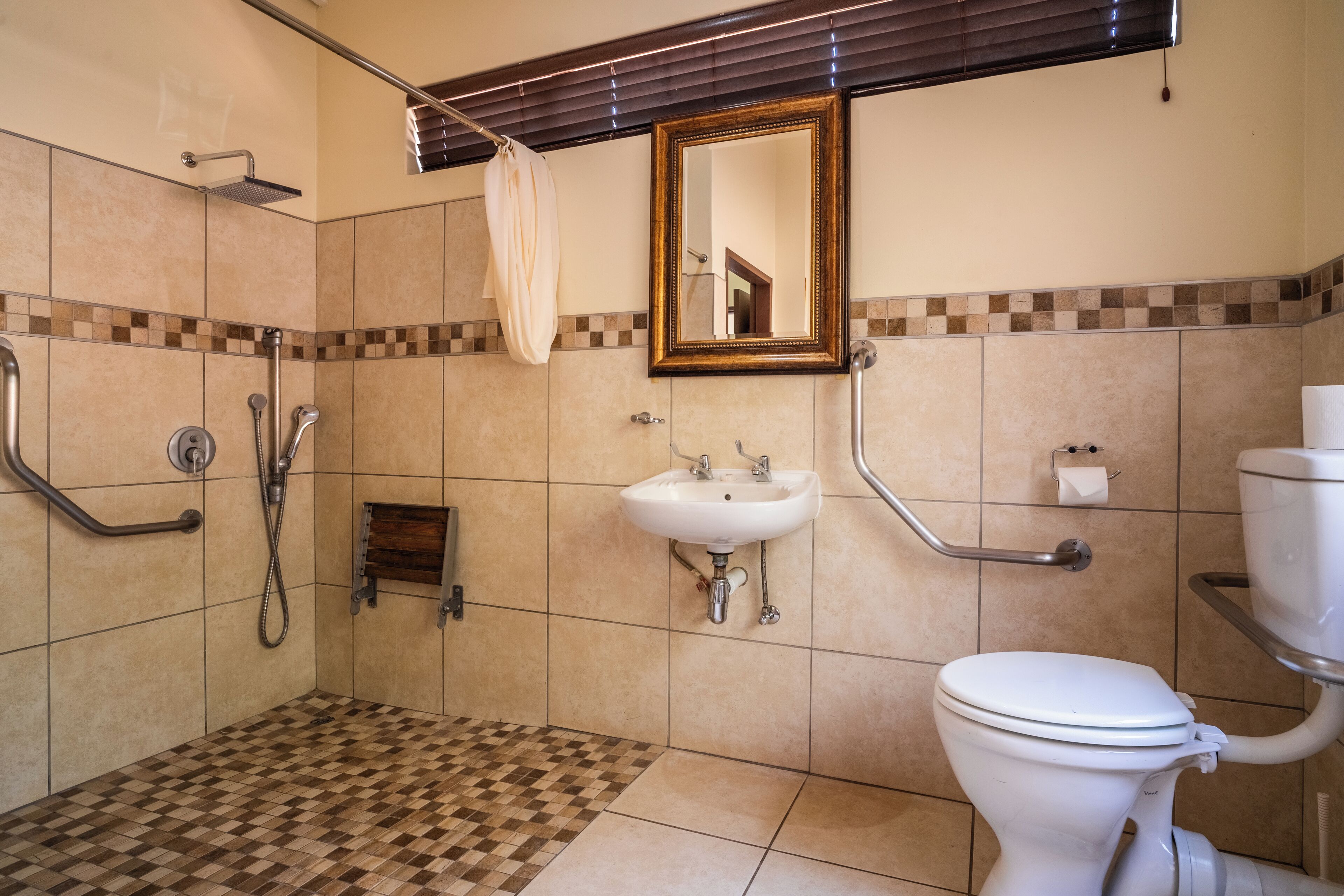 A bathroom with a shower, sink, toilet, and a mirror.