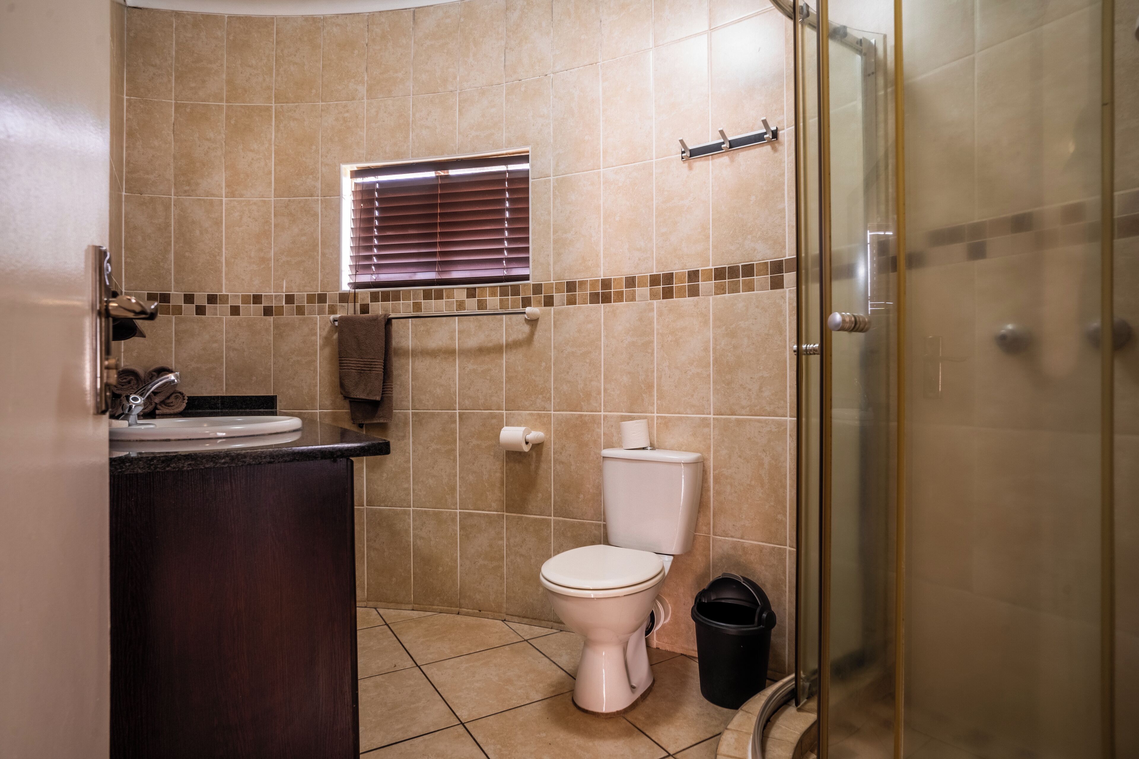 A bathroom with a toilet, sink, and shower area.