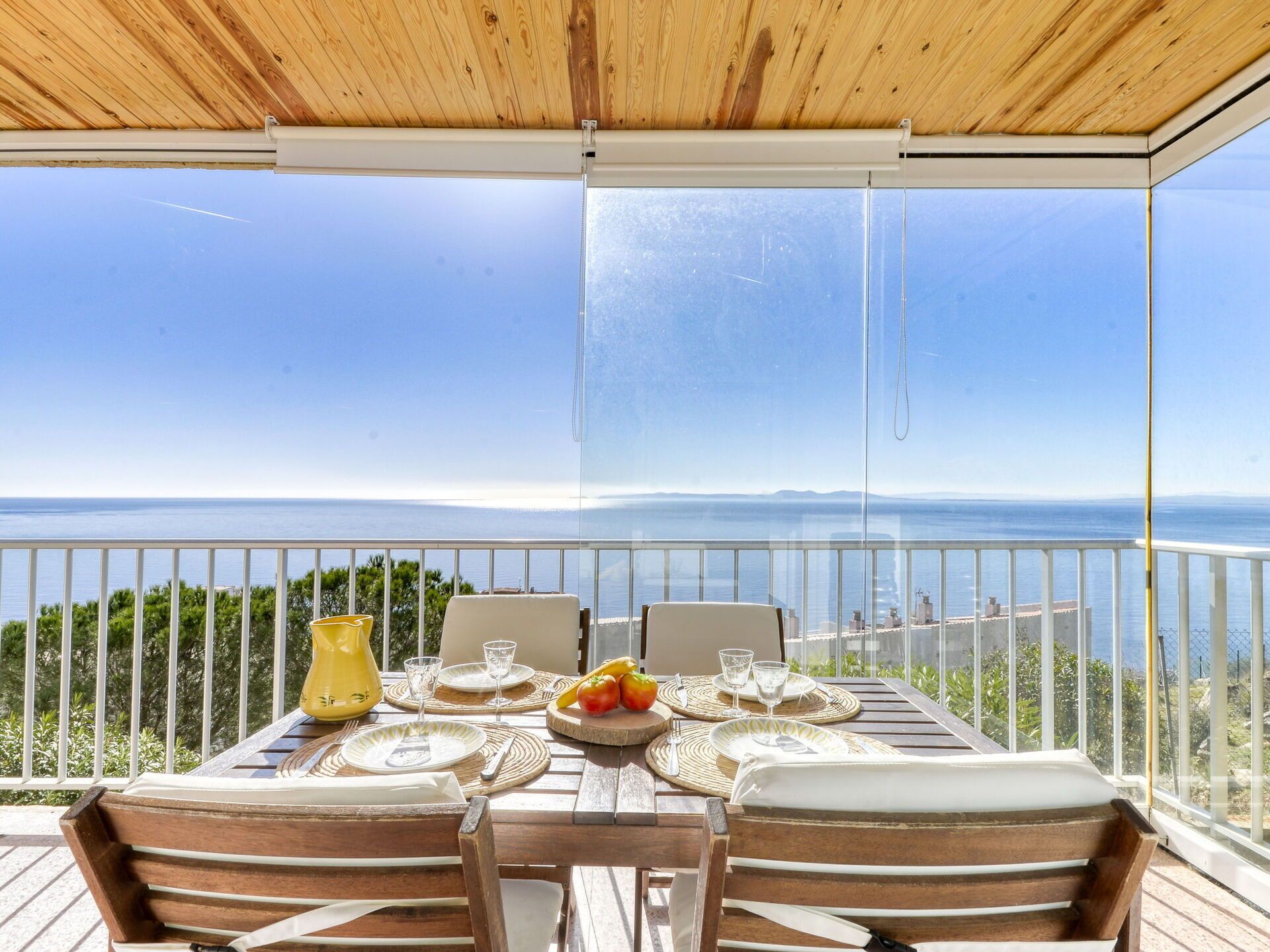 A dining table set for two with a view of the sea.