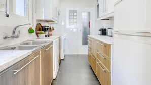 A modern kitchen with white cabinets, a stainless steel sink, and a built-in oven. - Nice apartment for 6 guests with WIFI, TV and terrace (Roses)