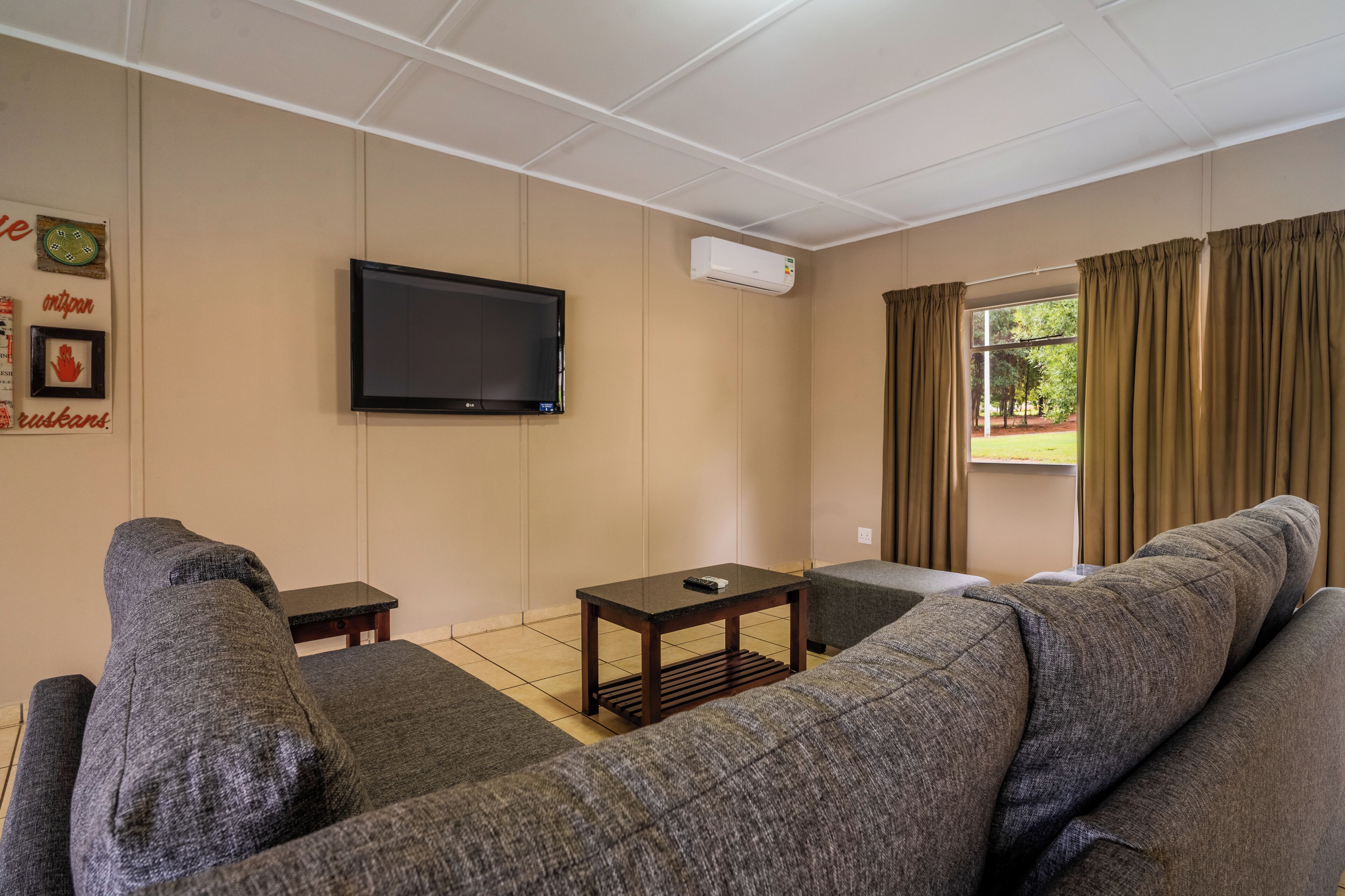 A living room with a flat-screen TV, a small table, and a sofa.
