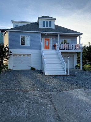 A two-story house with a front porch, a staircase, and a garage.