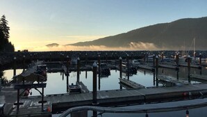 Uma marina com várias docas e barcos, rodeada por uma paisagem montanhosa.