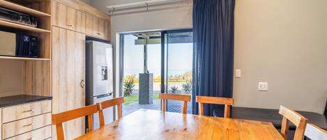 A modern kitchen with wooden cabinets, a built-in microwave, and a large window with a view of the outdoors.