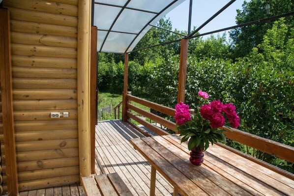 Una terraza de madera con un banco y una planta en maceta.