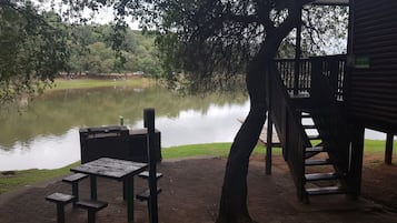 Sit and enjoy the serene surroundings from this outdoor seating area overlooking a tranquil body of water.
